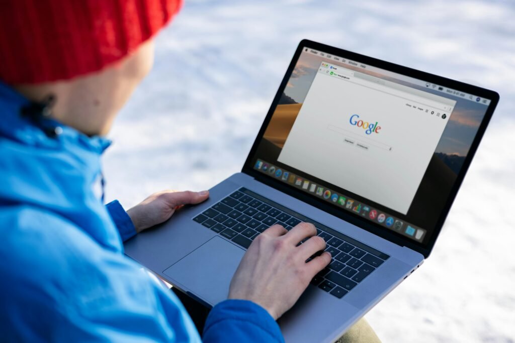 Local SEO for Calgary Small Businesses: Where to Start Person in winter gear using a laptop with a Google search on screen outdoors.
