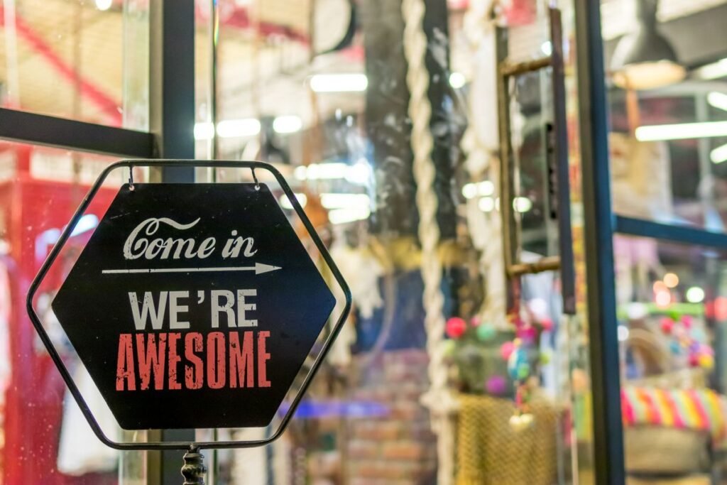 Storefront sign reading Come in we're awesome at a local shop entrance